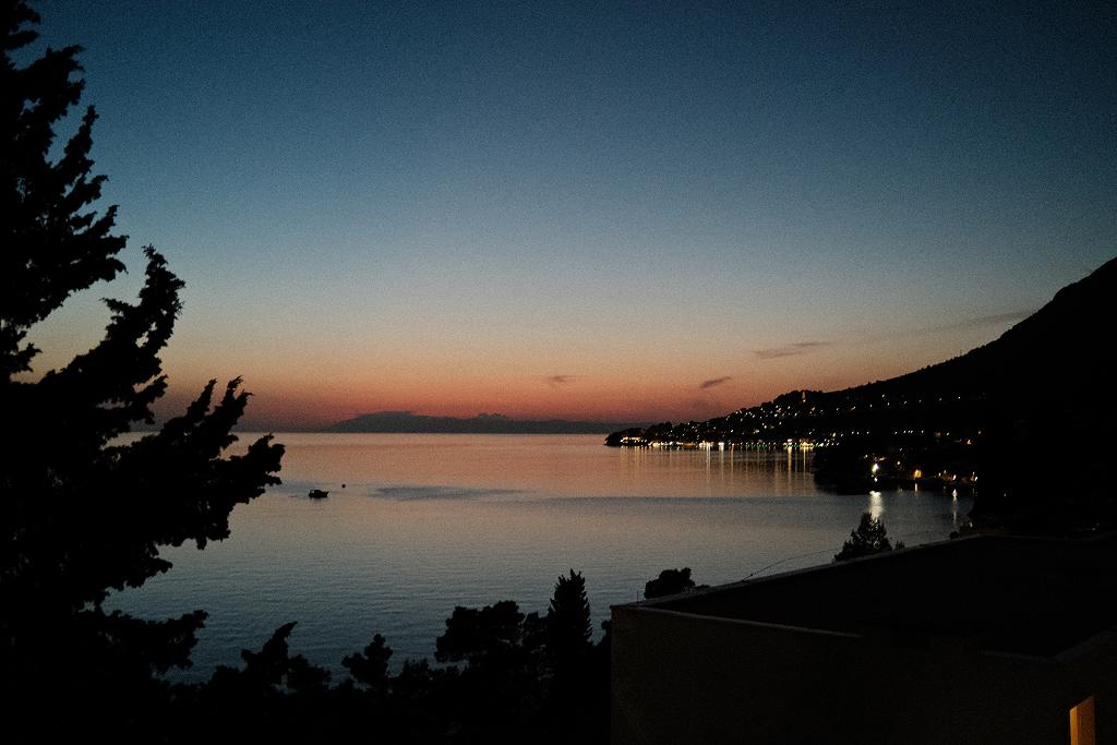 The sea at dusk, with lights along the coastline