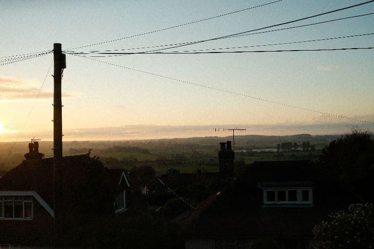 Rooftops and telephone wires at sunset